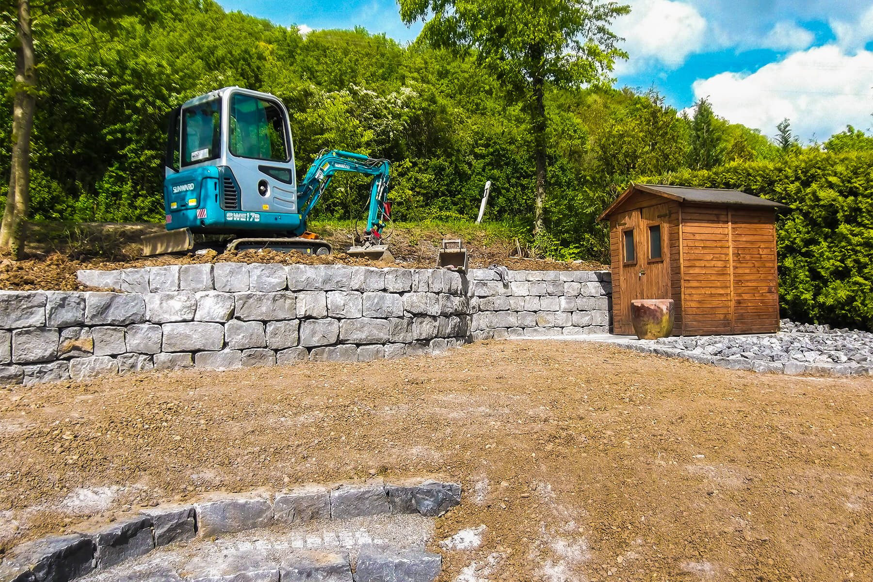 Errichtung einer Natursteinmauer aus Muschelkalk mit dem Mini-Bagger von Dewald Garten & Zaun in Ingelfingen-Dörrenzimmern, Kreis K%uuml;nzelsau